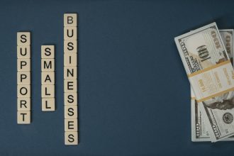 Conceptual image of supporting small businesses with financial resources using money and letter tiles.