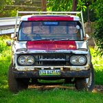 Rusted vintage Toyota truck parked in grassy field, Manzini, Eswatini.