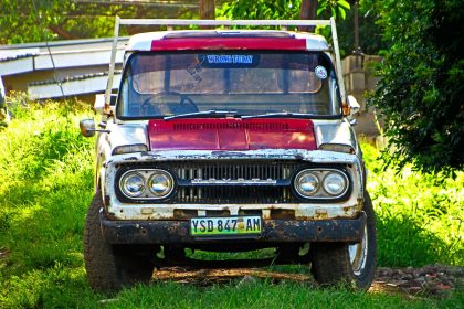 Rusted vintage Toyota truck parked in grassy field, Manzini, Eswatini.