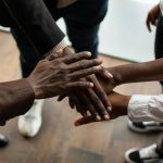High angle view of diverse hands stacked together, symbolizing teamwork and unity.