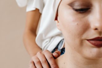 Close-up of a cancer patient being comforted by a friend, emphasizing support and care.