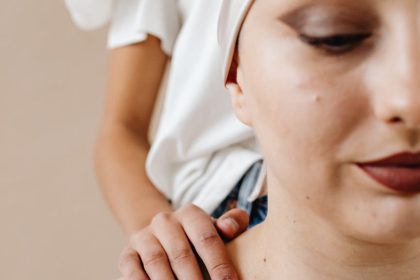 Close-up of a cancer patient being comforted by a friend, emphasizing support and care.