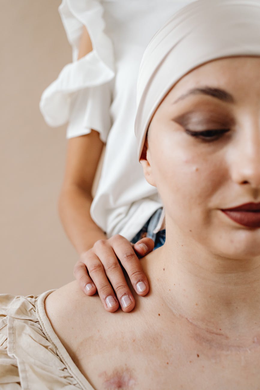Close-up of a cancer patient being comforted by a friend, emphasizing support and care.