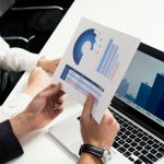 Business professionals discussing data charts and graphs in a modern office setting.