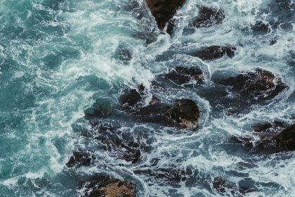 Powerful ocean waves crashing against rocks, capturing the force of the sea.