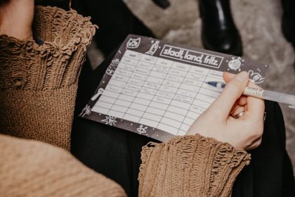 A woman writing on a paper playing a word game during a social gathering.