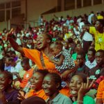 Lively scene of a diverse crowd enjoying a vibrant event at a stadium, capturing community spirit.