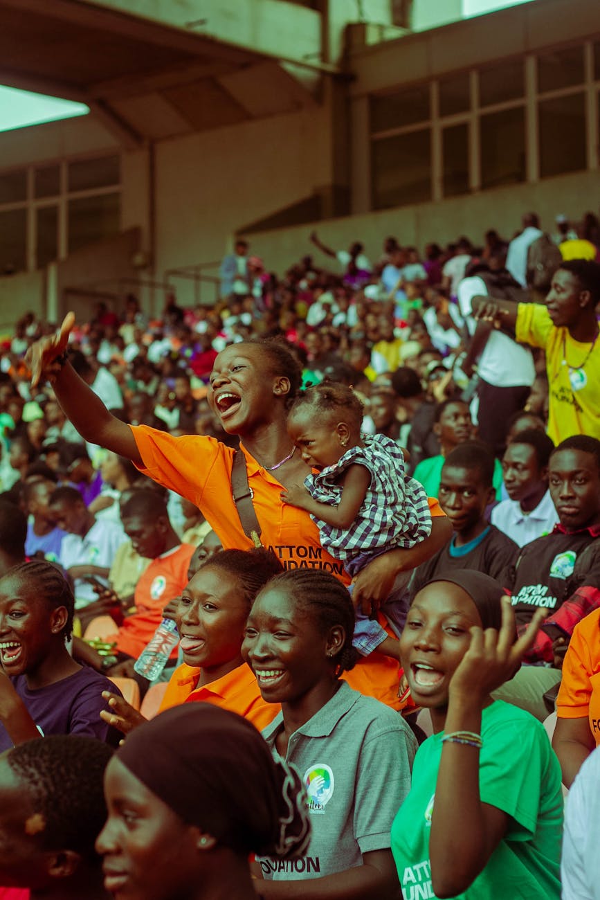 Lively scene of a diverse crowd enjoying a vibrant event at a stadium, capturing community spirit.