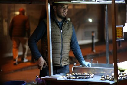 A street vendor selling roasted chestnuts at night in Türkiye.