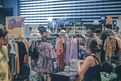 Vibrant indoor clothing market scene with diverse shoppers browsing and buying fashionable apparel.