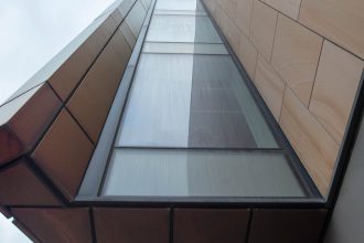 A striking view of contemporary architecture capturing geometric shapes and glass facade from below.