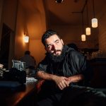 Atmospheric portrait of a man in a cozy Londen café with warm lighting.
