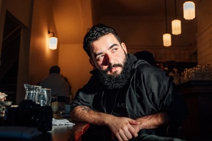 Atmospheric portrait of a man in a cozy Londen café with warm lighting.
