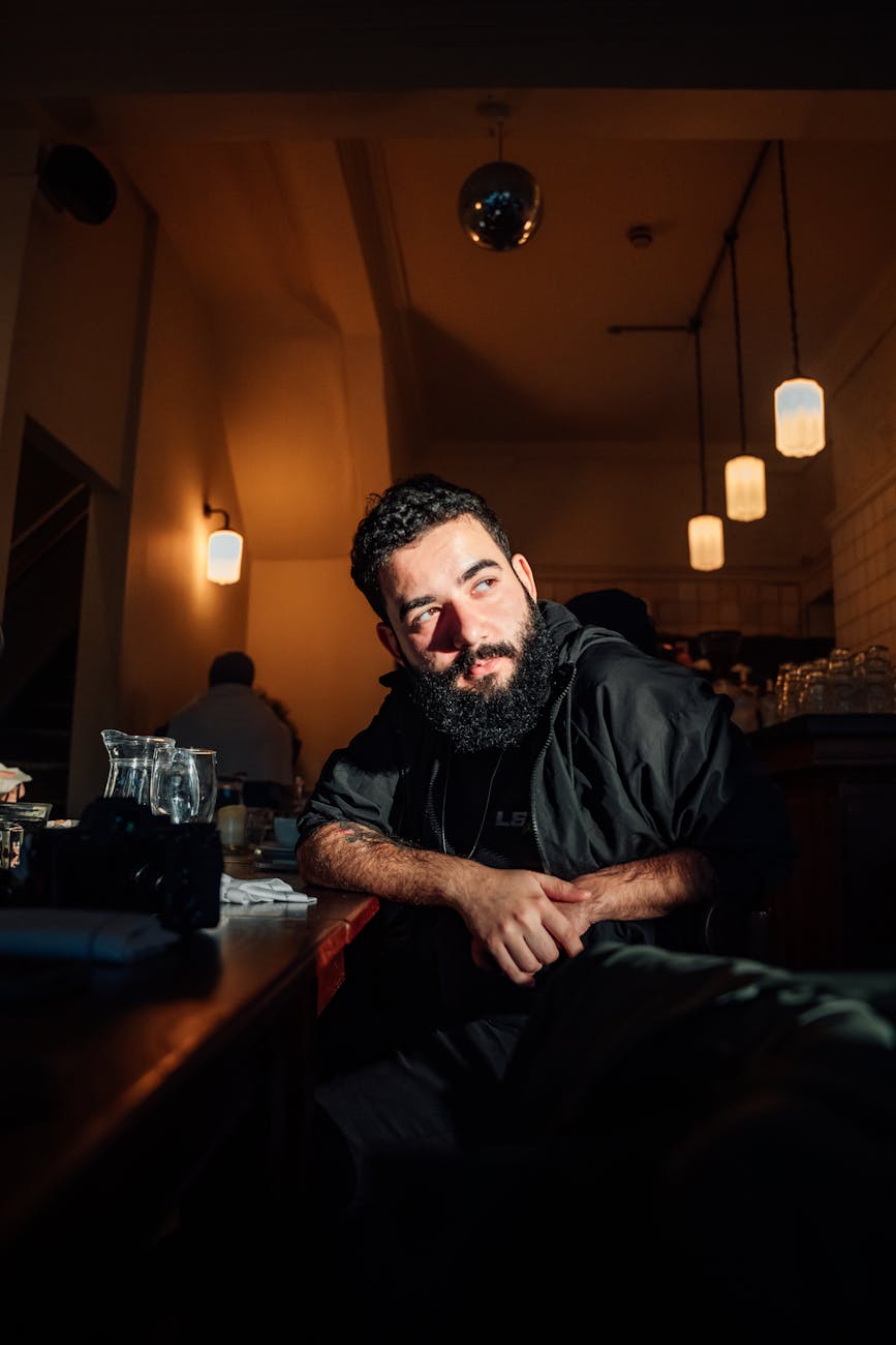 Atmospheric portrait of a man in a cozy Londen café with warm lighting.