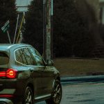 A car navigates rainy city streets in Monsey, NY, showcasing an urban vibe.