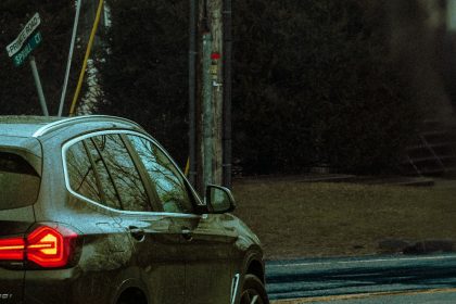 A car navigates rainy city streets in Monsey, NY, showcasing an urban vibe.