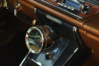Interior view of a vintage car dashboard featuring retro audio equipment and classic design elements.