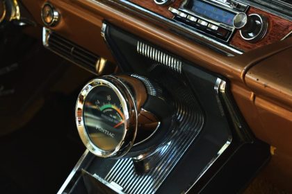 Interior view of a vintage car dashboard featuring retro audio equipment and classic design elements.