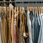 A diverse selection of clothing items arranged on hangers in a store setting, showcasing fashion trends.