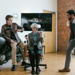 Three individuals enjoying a virtual reality experience in a modern indoor setting.