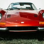 Front view of a vintage red car displayed at a Farmington auto show.