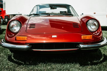 Front view of a vintage red car displayed at a Farmington auto show.